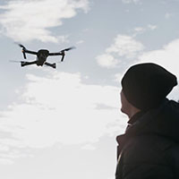 low angle man watching drone 1